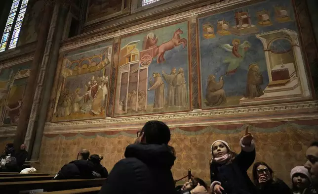 People admire Giotto's frescoes inside St. Francis Basilica in Assisi, Italy, Saturday, March 1, 2025. (AP Photo/Gregorio Borgia)