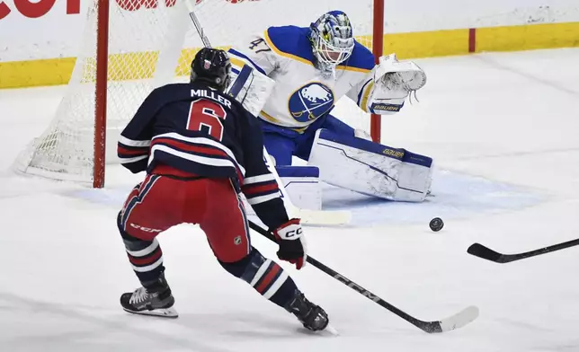 Buffalo Sabres' goaltender James Reimer (47) makes a save against Winnipeg Jets' Colin Miller (6) during the first period of an NHL hockey game in Winnipeg, Manitoba, Sunday March 23, 2025. (Fred Greenslade/The Canadian Press via AP)