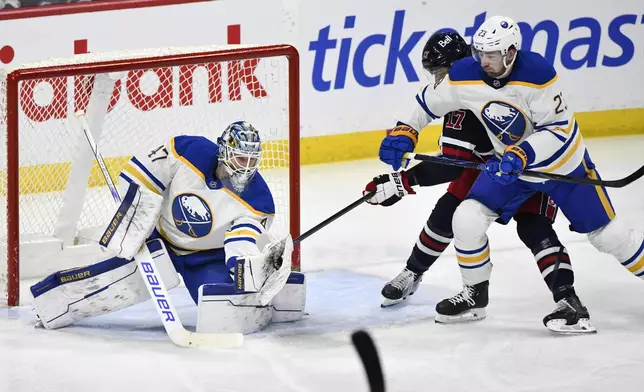 Buffalo Sabres' goaltender James Reimer (47) makes a save against a Winnipeg Jets shot as Sabres' Mattias Samuelsson (23) defends against Jeys' Adam Lowry (17) during the first period of an NHL hockey game in Winnipeg, Manitoba, Sunday March 23, 2025. (Fred Greenslade/The Canadian Press via AP)