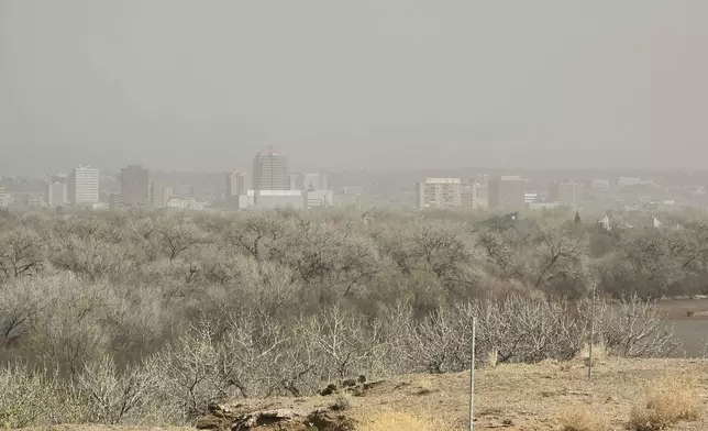 Dust shrouds buildings in Albuquerque, N.M., Tuesday, March 18, 2025. (AP Photo/Felicia Fonseca)