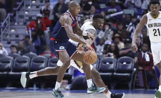 Los Angeles Clippers guard Kris Dunn (8), left, and New Orleans Pelicans forward Zion Williamson (1) vie for a loose ball in the second half of an NBA basketball game in New Orleans, Tuesday, March 11, 2025. (AP Photo/Peter Forest)