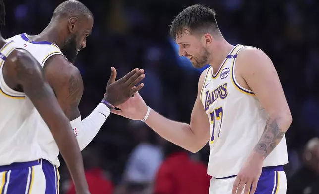 Los Angeles Lakers guard Luka Doncic, right, is congratulated by forward LeBron James after scoring during the first half of an NBA basketball game against the Los Angeles Clippers, Sunday, March 2, 2025, in Los Angeles. (AP Photo/Mark J. Terrill)