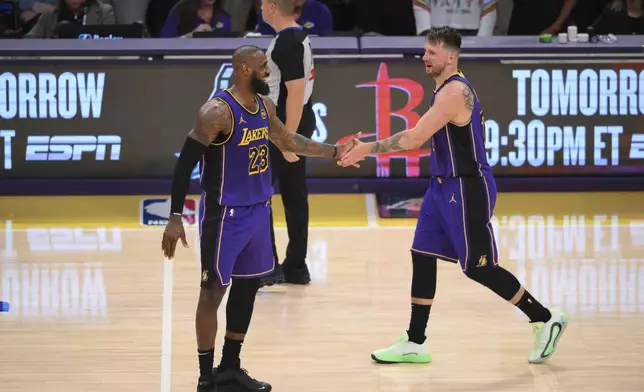 Los Angeles Lakers forward LeBron James (23) and guard Luka Doncic (77) shake hands during the second half of an NBA basketball game against the Dallas Mavericks, Tuesday, Feb. 25, 2025, in Los Angeles. (AP Photo/Kyusung Gong)