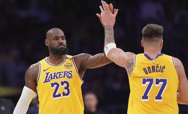 Los Angeles Lakers forward LeBron James, left, is congratulated by guard Luka Doncic after he scored during the first half of an NBA basketball game against the Minnesota Timberwolves, Thursday, Feb. 27, 2025, in Los Angeles. (AP Photo/Mark J. Terrill)