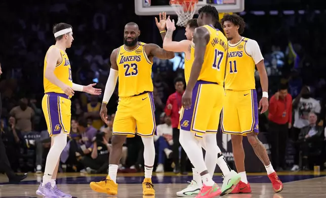 Los Angeles Lakers guard Luka Doncic, center, is congratulated after scoring by forward LeBron James, second from left, guard Austin Reaves, left, forward Dorian Finney-Smith, forward Dorian Finney-Smith, second from right, and center Jaxson Hayes during the second half of an NBA basketball game against the Minnesota Timberwolves, Thursday, Feb. 27, 2025, in Los Angeles. (AP Photo/Mark J. Terrill)
