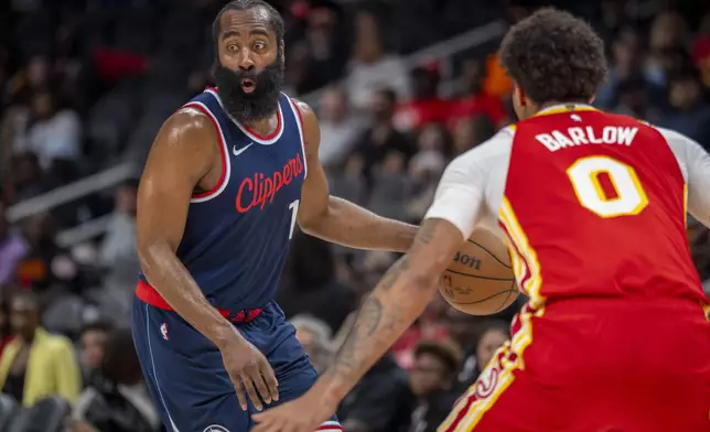 Los Angeles Clippers guard James Harden (1), left, attempts to pass the ball against Atlanta Hawks forward Dominick Barlow (0), right, during the first half of an NBA basketball game, Friday, March 14, 2025, in Atlanta. (AP Photo/Erik Rank)