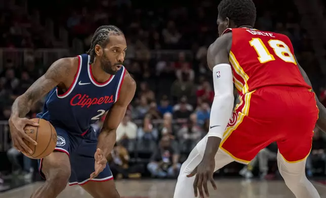Los Angeles Clippers forward Kawhi Leonard (2), left, moves the ball against Atlanta Hawks forward Mouhamed Gueye (18), right, during the first half of an NBA basketball game, Friday, March 14, 2025, in Atlanta. (AP Photo/Erik Rank)