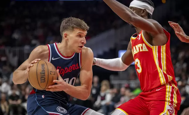 Los Angeles Clippers guard Bogdan Bogdanovic (10), left, moves the ball against Atlanta Hawks guard Caris LeVert (3), right, during the first half of an NBA basketball game, Friday, March 14, 2025, in Atlanta. (AP Photo/Erik Rank)