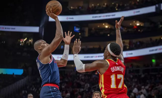 Los Angeles Clippers guard Kris Dunn (8), left, makes a basket against Atlanta Hawks forward Onyeka Okongwu (17), right, during the first half of an NBA basketball game, Friday, March 14, 2025, in Atlanta. (AP Photo/Erik Rank)