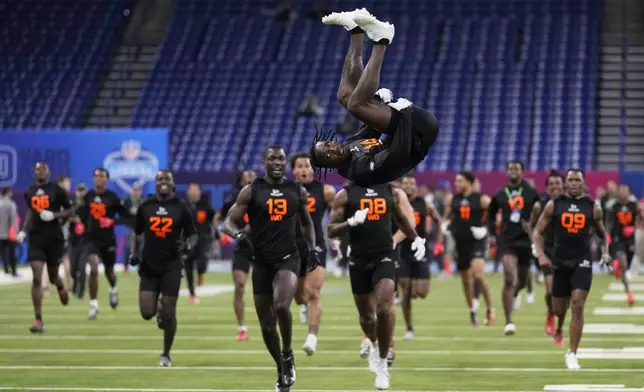 Maryland wide receiver Tai Felton does a backflip as wide receiver prospects run to the end zone to celebrate after running drills at the NFL football scouting combine in Indianapolis, Saturday, March 1, 2025. (AP Photo/George Walker IV)