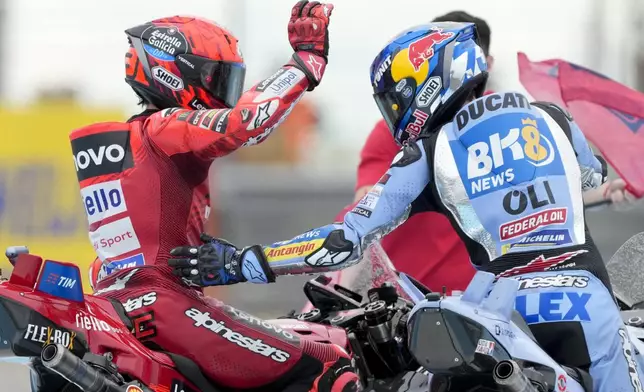 MotoGP race winner Spain's Marc Marquez of the Ducati Lenovo Team, left, celebrates with second place Spain's Alex Marquez of the BK8 Gresini Racing MotoGP Team in Termas de Rio Hondo circuit, Argentina, Sunday, March 16, 2025. (AP Photo/Gustavo Garello)