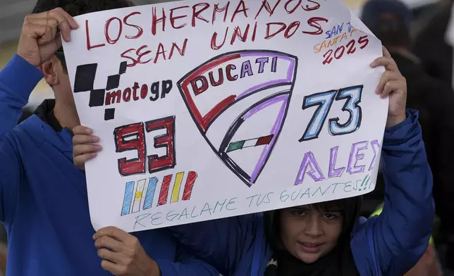 A spectator holds a banner reading in Spanish "Brothers, be united" in reference to MotoGP competitors Marc Marquez and Alex Marquez, both of Spain, in Termas de Rio Hondo, Argentina, Sunday, March 16, 2025. (AP Photo/Gustavo Garello)