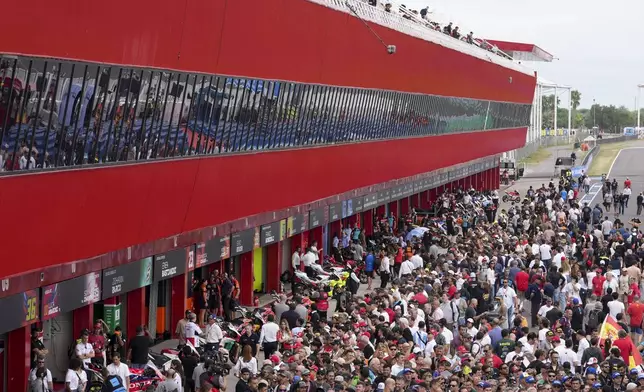 Spectators visit the pit line prior to the MotoGP race in Termas de Rio Hondo, Argentina, Sunday, March 16, 2025. (AP Photo/Gustavo Garello)