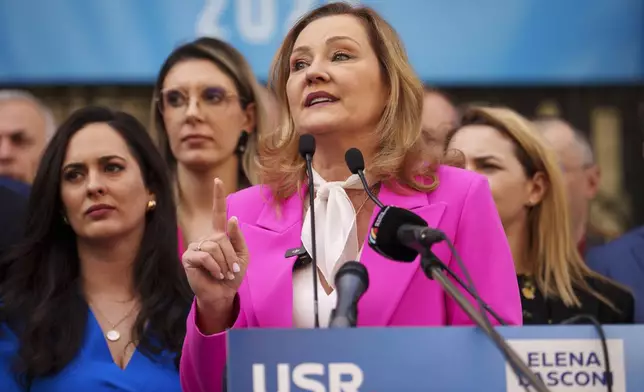 Elena Lasconi, presidential candidate for the Save Romania Union (USR) party, gestures outside the electoral authority after registering her bid to enter the May presidential election rerun in Bucharest, Romania, Thursday, March 13, 2025. (AP Photo/Vadim Ghirda)