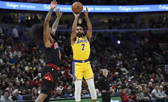 Los Angeles Lakers' Gabe Vincent (7) goes up for a shot against Chicago Bulls' Coby White (0) during the first half of an NBA basketball game Thursday, March 27, 2025, in Chicago. (AP Photo/Paul Beaty)