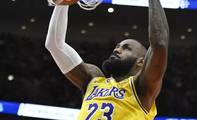Los Angeles Lakers' LeBron James dunks during the first half of an NBA basketball game against the Chicago Bulls Thursday, March 27, 2025, in Chicago. (AP Photo/Paul Beaty)