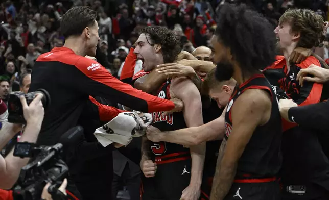 Chicago Bulls' Josh Giddy (3) celebrates with teammates after making the winning basket in an NBA basketball game against the Los Angeles Lakers Thursday, March 27, 2025, in Chicago. (AP Photo/Paul Beaty)