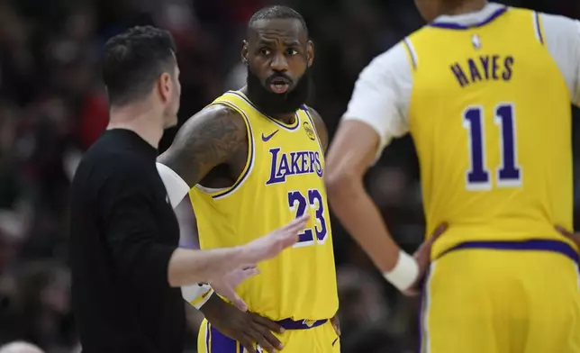 Los Angeles Lakers' LeBron James (23) talks with head coach JJ Redick left, during the second half of an NBA basketball game against the Chicago Bulls Thursday, March 27, 2025, in Chicago. (AP Photo/Paul Beaty)