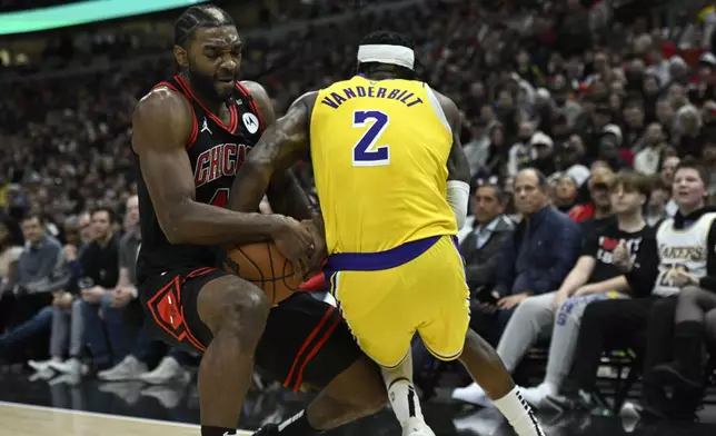 Chicago Bulls' Patrick Williams (44) battles Los Angeles Lakers' Jarred Vanderbilt (2) for a loose ball during the first half of an NBA basketball game Thursday, March 27, 2025, in Chicago. (AP Photo/Paul Beaty)