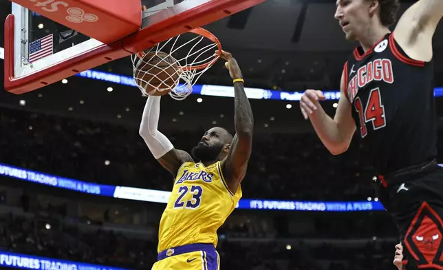 Los Angeles Lakers' LeBron James dunks during the first half of an NBA basketball game against the Chicago Bulls Thursday, March 27, 2025, in Chicago. (AP Photo/Paul Beaty)