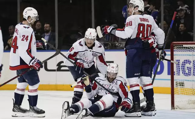 Washington Capitals' Tom Wilson (43) celebrates with teammates Jakob Chychrun (6), Pierre-Luc Dubois (80) and Connor McMichael (24) after scoring the game-winning goal during the overtime period of an NHL hockey game against the New York Rangers Wednesday, March 5, 2025, in New York. (AP Photo/Frank Franklin II)