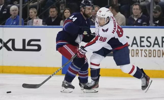 Washington Capitals' Andrew Mangiapane (88) shoots the puck past New York Rangers' Calvin de Haan (44) during the first period of an NHL hockey game Wednesday, March 5, 2025, in New York. (AP Photo/Frank Franklin II)