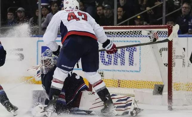 Washington Capitals' Tom Wilson (43) scores a goal as New York Rangers goaltender Igor Shesterkin (31) defends during the overtime period of an NHL hockey game Wednesday, March 5, 2025, in New York. (AP Photo/Frank Franklin II)