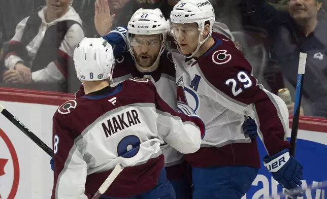 Colorado Avalanche center Nathan MacKinnon (29) celebrates after a goal against the Ottawa Senators with teammates left wing Jonathan Drouin, center, and defenseman Cale Makar, le during first-period NHL hockey game action, Thursday, March 20, 2025, in Ottawa, Ontario. (Adrian Wyld/The Canadian Press via AP)