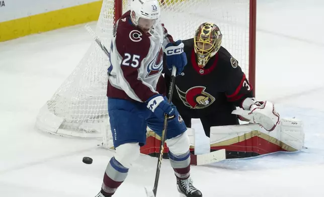 Colorado Avalanche right wing Logan O'Connor (25) tries to screen Ottawa Senators goaltender Anton Forsberg, right, on a shot during second-period NHL hockey game action, Thursday, March 20, 2025, in Ottawa, Ontario. (Adrian Wyld/The Canadian Press via AP)