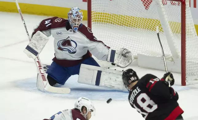 Colorado Avalanche goaltender Scott Wedgewood (41) makes a pad-save on a shot by Ottawa Senators center Tim Stutzle, right, during second-period NHL hockey game action, Thursday, March 20, 2025, in Ottawa, Ontario. (Adrian Wyld/The Canadian Press via AP)