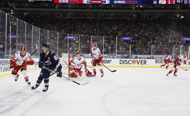 Detroit Red Wings' Albert Johansson, left, and Columbus Blue Jackets' Mikael Pyyhtia chase the puck during the second period of the Stadium Series NHL hockey game at Ohio Stadium, Saturday, March 1, 2025, in Columbus, Ohio. (AP Photo/Jay LaPrete)