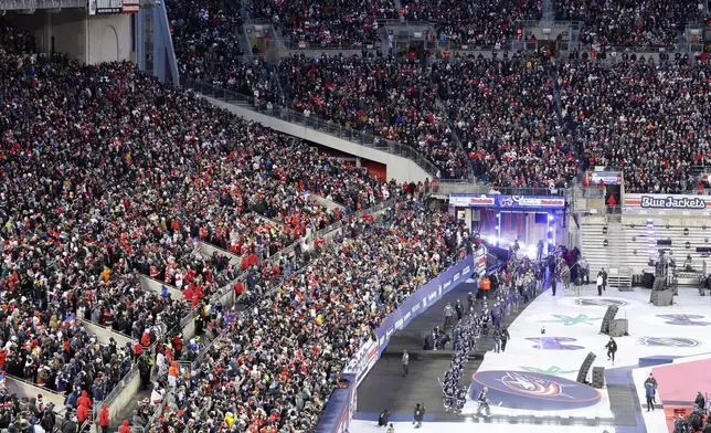 The Columbus Blue Jackets enter Ohio Stadium before the start of the Stadium Series NHL hockey game between the against the Detroit Red Wings Saturday, March 1, 2025, in Columbus, Ohio. (AP Photo/Jay LaPrete)