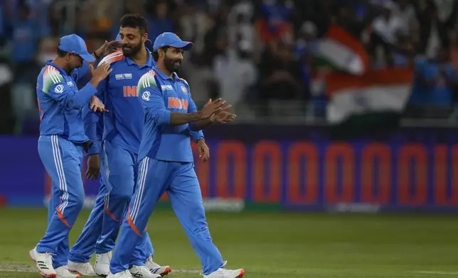 India's Varun Chakravarthy, second from left, celebrate the wicket of New Zealand's Matt Henry with his team mates during the ICC Champions Trophy cricket match between India and New Zealand at Dubai International Cricket Stadium in Dubai, United Arab Emirates, Sunday, March 2, 2025. (AP Photo/Altaf Qadri )