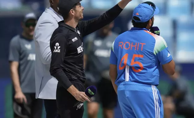 India's captain Rohit Sharma, right, watches as New Zealand's captain Mitch Santner flips the coin at the toss ahead of the ICC Champions Trophy cricket match between India and New Zealand at Dubai International Cricket Stadium in Dubai, United Arab Emirates, Sunday, March 2, 2025. (AP Photo/Altaf Qadri)