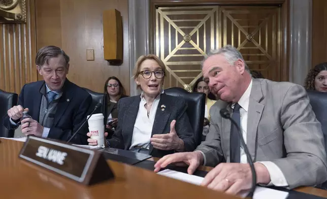 Sen. John Hickenlooper, D-Colo., from left, Sen. Maggie Hassan, D-N.H., and Sen. Tim Kaine, D-Va., talk as the Health, Education, Labor and Pensions (HELP) Committee meets to consider President Donald Trump's nominations for the director of the National Institutes of Health, and the commissioner of the Food and Drug Administration, on Capitol Hill in Washington, Thursday, March 13, 2025. (AP Photo/J. Scott Applewhite)