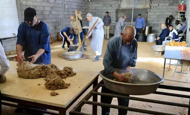 Volunteers serve traditional unleavened Libyan bread made out of barley in Tajoura, east of Libya's capital Tripoli, Tuesday, March 11, 2025, during the Muslim holy month of Ramadan. (AP Photo/Yousef Murad)