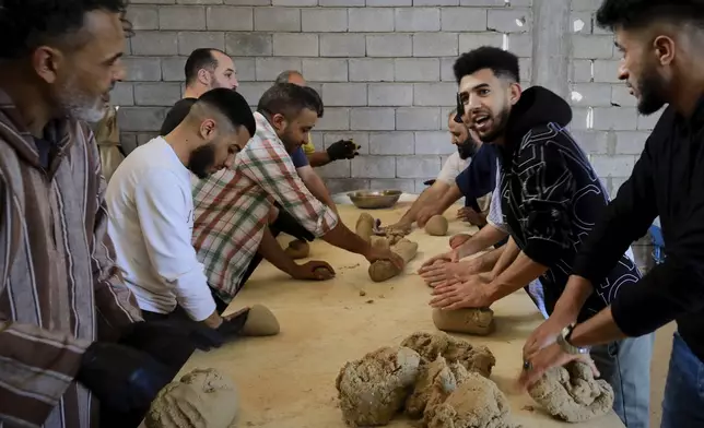 Volunteers prepare Bazin, traditional Libyan dough bread made of barley or whole wheat flour and often served with stew in Tajoura, east of Libya's capital Tripoli, Tuesday, March 11, 2025, during the Muslim holy month of Ramadan. (AP Photo/Yousef Murad)
