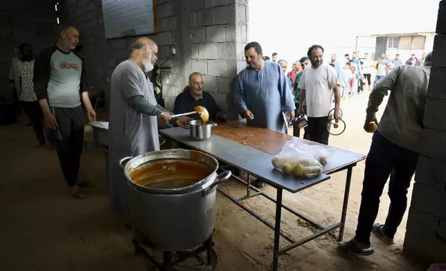 Libyan volunteers serve free traditional unleavened Libyan bread made out of barley for passing fasting people in Tajoura, east of Libya's capital Tripoli, Tuesday, March 11, 2025, during the Muslim holy month of Ramadan. (AP Photo/Yousef Murad)