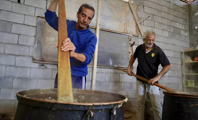 Libyan volunteers prepare Bazin, traditional Libyan dough bread made of barley or whole wheat flour and often served with stew in Tajoura, east of Libya's capital Tripoli, Tuesday, March 11, 2025, during the Muslim holy month of Ramadan. (AP Photo/Yousef Murad)