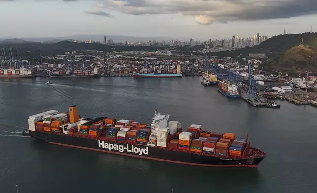 A cargo ship sails past the Panama Canal's Port of Balboa, managed by CK Hutchison Holdings, in Panama City, Thursday, March 13, 2025. (AP Photo/Matias Delacroix)