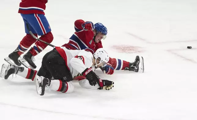 Montreal Canadiens' Patrik Laine (92) is tripped by Ottawa Senators' Artem Zub (2) during second period NHL hockey action in Montreal on Tuesday, March 18, 2025. (Christinne Muschi/The Canadian Press via AP)