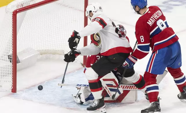 Ottawa Senators' Michael Amadio (22) taps the puck in behind Montreal Canadiens goaltender Sam Montembeault (35) as Canadiens' Mike Matheson (8) looks on during second period NHL hockey action in Montreal on Tuesday, March 18, 2025. (Christinne Muschi/The Canadian Press via AP)