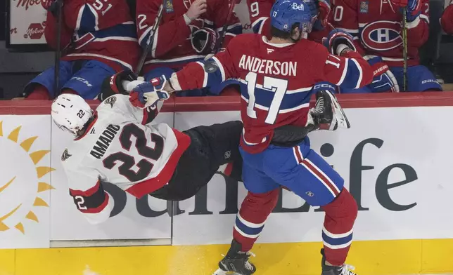 Ottawa Senators' Michael Amadio (22) is checked into the boards by Montreal Canadiens' Josh Anderson (17) during first period NHL hockey action in Montreal on Tuesday, March 18, 2025. (Christinne Muschi/The Canadian Press via AP)