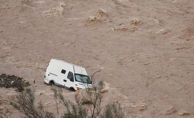 A van is photographed being swept away by the flood in Casasola, Malaga, Spain, Tuesday, March 18, 2025. (AP Photo/Gregorio Marrero)