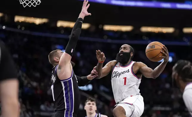 Los Angeles Clippers guard James Harden, right, shoots as Sacramento Kings center Jonas Valanciunas defends during the second half of an NBA basketball game Sunday, March 9, 2025, in Inglewood, Calif. (AP Photo/Mark J. Terrill)