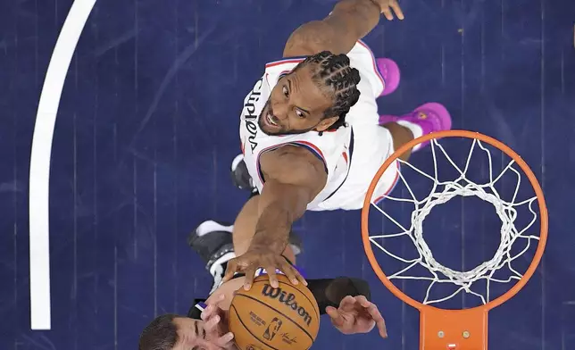 Los Angeles Clippers forward Kawhi Leonard, top, blocks the shot of Sacramento Kings center Jonas Valanciunas during the second half of an NBA basketball game Sunday, March 9, 2025, in Inglewood, Calif. (AP Photo/Mark J. Terrill)