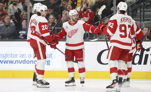 Detroit Red Wings right wing Alex DeBrincat (93) celebrates with teammates after his goal during the third period of an NHL hockey game against the Vegas Golden Knights, Saturday, March 22, 2025, in Las Vegas. (AP Photo/Ian Maule)