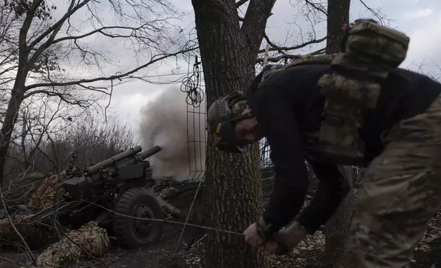 Ukrainian serviceman of Khartia brigade known by call sign "Krystal" fires M101 Howitzer towards Russian positions in Kharkiv region, Ukraine, Wednesday, March 12, 2025. (AP Photo/Alex Babenko)
