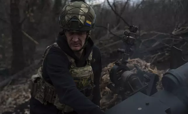 Ukrainian serviceman of Khartia brigade known by call sign "Krystal" check M101 Howitzer after firing towards Russian positions in Kharkiv region, Ukraine, Wednesday, March 12, 2025. (AP Photo/Alex Babenko)