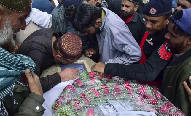 Mourners gather around a casket of a victim of a train attack, for a funeral prayer in Quetta, Pakistan's southwestern Balochistan province, Thursday March 13, 2025. (AP Photo/Arshad Butt)